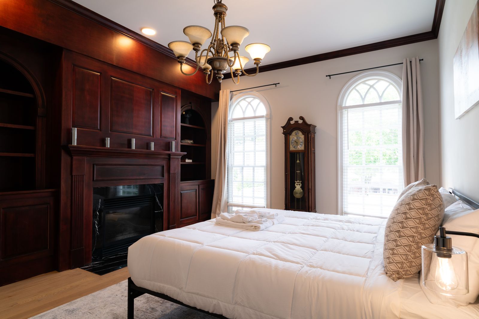 Bedroom with cherry built in cabinetry and panelled fireplace